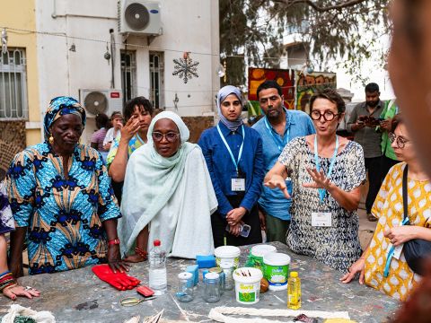 Dakar-based Artisan Cecile Ndiaye explaining to participants of the AA3 ConFest about the different materials needed for dyeing.