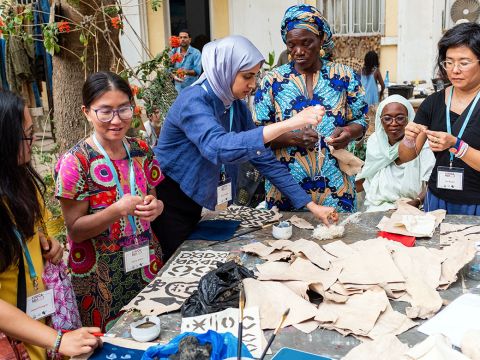 Participants using brushes on basilanfini cloth to create their own designs.
